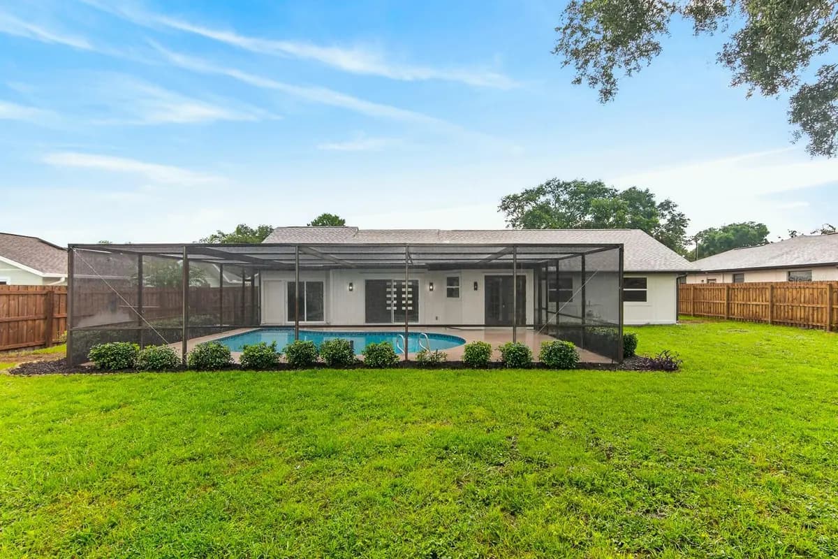 Backyard and screened pool at a featured Palm Harbor property