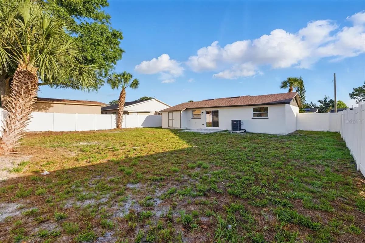 Back exterior and fenced yard of a featured property on Westridge Drive in Tampa